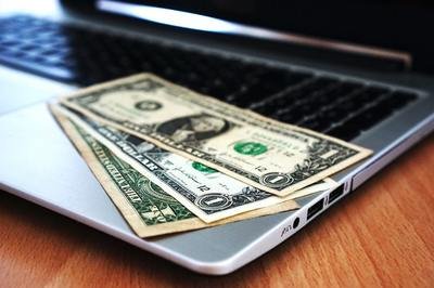 HRMS budget - computer with dollar bills HRMS budget - computer with dollar bills